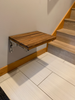 Teak folding bench used in entryway as place to sit to put on shoes